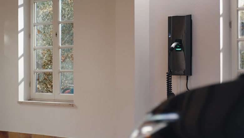 Compleo SOLO smart Wallbox an der Hauswand neben einem Fenster